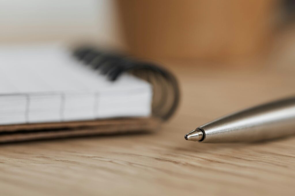 Close up image of a pen and pad on paper on a desk.