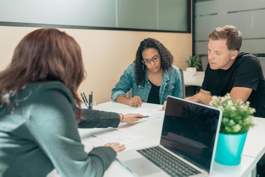 A student and faculty member meet with a member of the campus support staff.